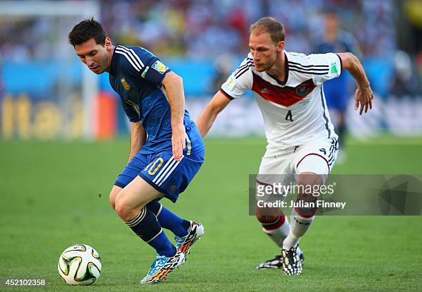 Lionel Messi of Argentina controls the ball against Benedikt Hoewedes of Germany during the 2014 FIFA World Cup Brazil Final match between Germany...