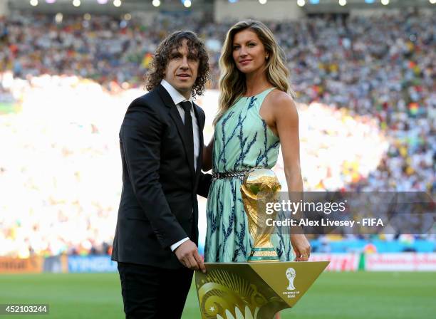 Former Spanish international Carles Puyol and model Gisele Bundchen present the World Cup from a Louis Vuitton travel case prior to the 2014 FIFA...