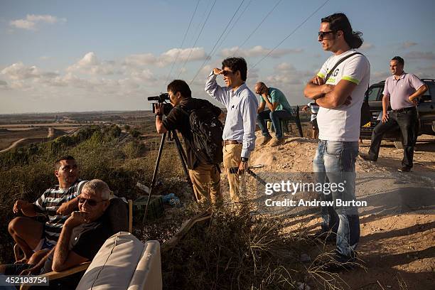 Civilians and members of the media wait to see Israeli attacks inside Gaza from the top of a hill on the sixth day of Israel's operation 'Protective...