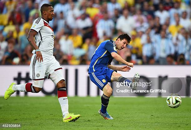 Lionel Messi of Argentina attempts a shot at goal as Jerome Boateng of Germany gives chase during the 2014 FIFA World Cup Brazil Final match between...