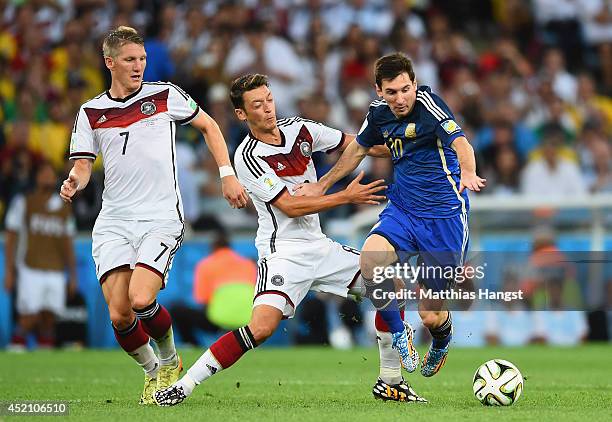 Lionel Messi of Argentina fights off Mesut Oezil of Germany during the 2014 FIFA World Cup Brazil Final match between Germany and Argentina at...