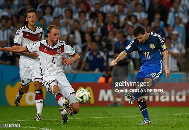 Germany's defender Benedikt Hoewedes and Argentina's forward and captain Lionel Messi vie for the ball during the 2014 FIFA World Cup final football...
