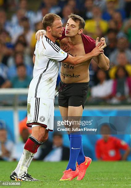 Pitch invader tries to kiss Benedikt Hoewedes of Germany during the 2014 FIFA World Cup Brazil Final match between Germany and Argentina at Maracana...