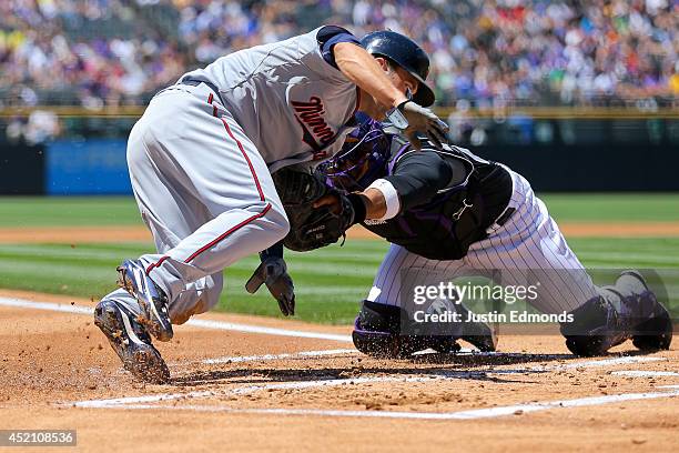 Catcher Wilin Rosario of the Colorado Rockies tags out Brian Dozier of the Minnesota Twins for the second out of the first inning at Coors Field on...