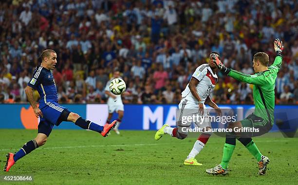 Rodrigo Palacio of Argentina shoots and misses wide against goalkeeper Manuel Neuer and Jerome Boateng of Germany during the 2014 FIFA World Cup...