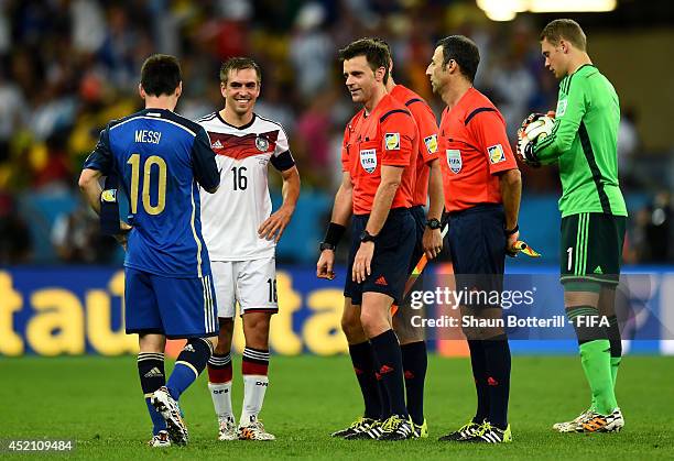 Lionel Messi of Argentina and Philipp Lahm of Germany approach to referee Nicola Rizzoli before the extra time during the 2014 FIFA World Cup Brazil...