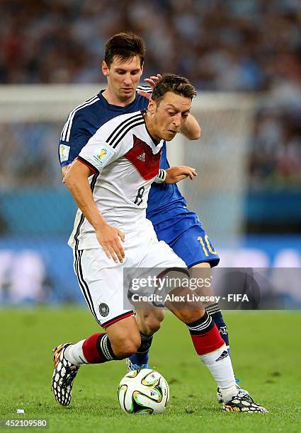 Mesut Oezil of Germany and Lionel Messi of Argentina compete for the ball during the 2014 FIFA World Cup Brazil Final match between Germany and...