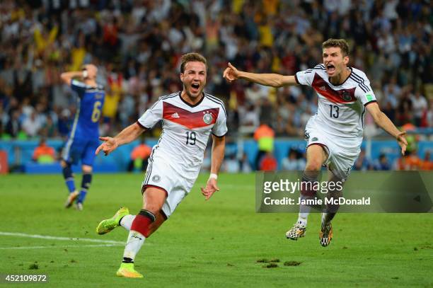 Mario Goetze of Germany celebrates scoring his team's first goal with Thomas Mueller during the 2014 FIFA World Cup Brazil Final match between...