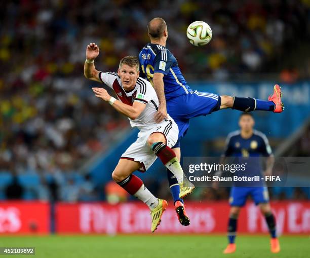Bastian Schweinsteiger of Germany and Rodrigo Palacio of Argentina compete for the ball during the 2014 FIFA World Cup Brazil Final match between...