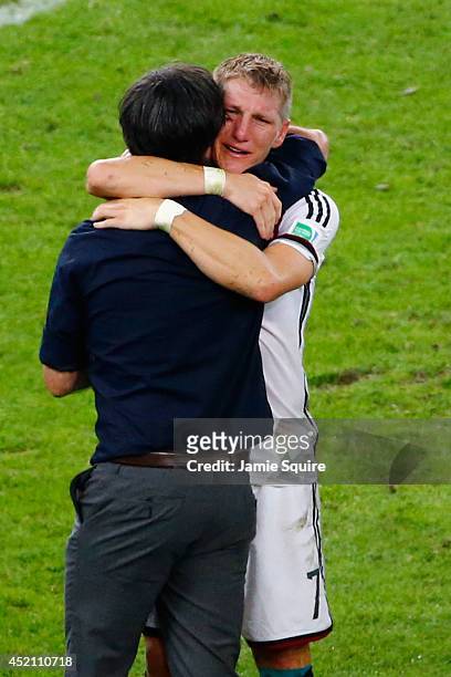 Head coach Joachim Loew of Germany and Bastian Schweinsteiger celebrate defeating Argentina 1-0 in the 2014 FIFA World Cup Brazil Final match between...