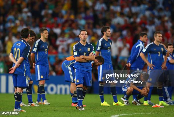 Dejected Maxi Rodriguez of Argentina looks on with teammates after being defeated by Germany 1-0 in extra time during the 2014 FIFA World Cup Brazil...