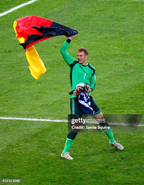 Manuel Neuer of Germany celebrates with a German flag after defeating Argentina 1-0 in extra time during the 2014 FIFA World Cup Brazil Final match...