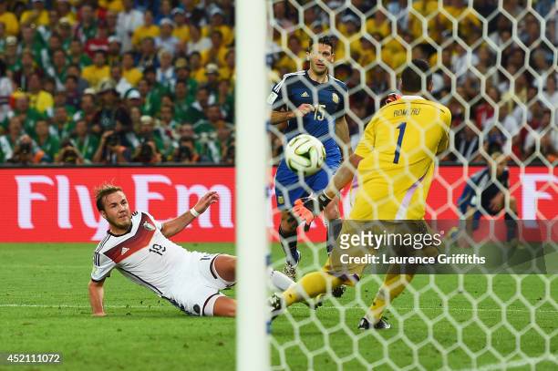 Mario Goetze of Germany scores his team's first goal past Sergio Romero of Argentina in extra time during the 2014 FIFA World Cup Brazil Final match...