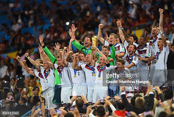 Philipp Lahm of Germany lifts the World Cup trophy after defeating Argentina 1-0 in extra time during the 2014 FIFA World Cup Brazil Final match...