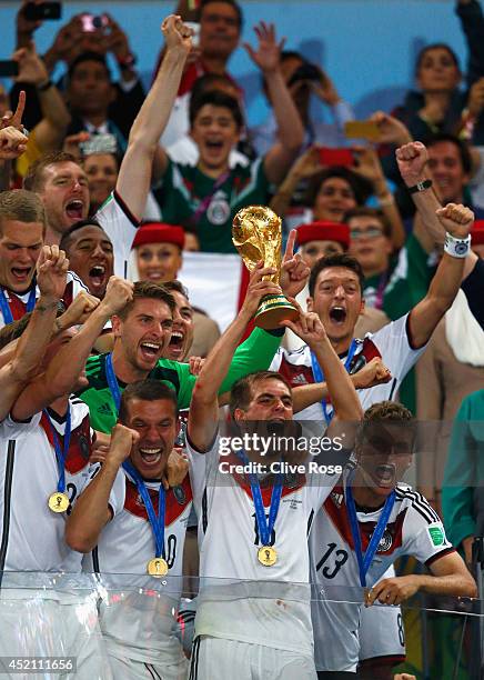 Philipp Lahm of Germany lifts the World Cup trophy with teammates after defeating Argentina 1-0 in extra time during the 2014 FIFA World Cup Brazil...