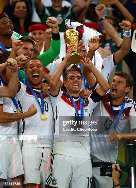 Philipp Lahm of Germany lifts the World Cup trophy with teammates after defeating Argentina 1-0 in extra time during the 2014 FIFA World Cup Brazil...