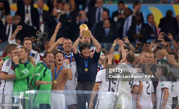 Head coach Joachim Loew of Germany lifts the World Cup to celebrate with his players during the award ceremony after the 2014 FIFA World Cup Brazil...