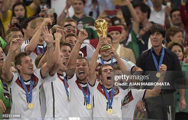 Germany's defender and captain Philipp Lahm holds up the World Cup trophy after winning the 2014 FIFA World Cup final football match between Germany...