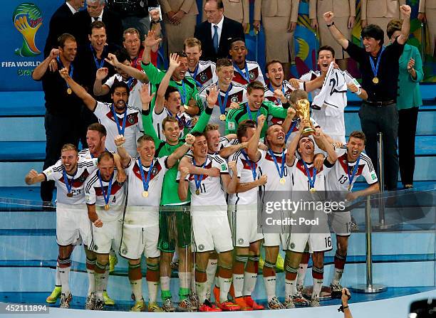 Philipp Lahm of Germany lifts the World Cup trophy with teammates after defeating Argentina 1-0 in extra time during the 2014 FIFA World Cup Brazil...