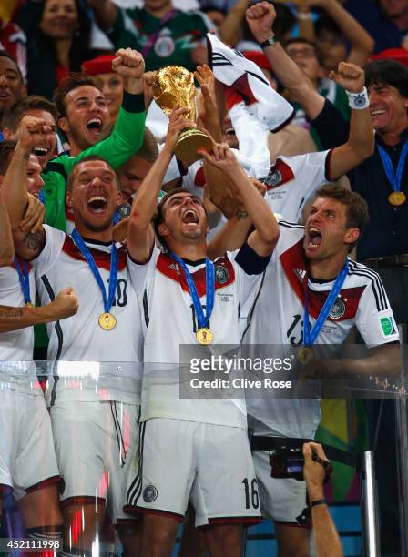 Philipp Lahm of Germany lifts the World Cup trophy with teammates after defeating Argentina 1-0 in extra time during the 2014 FIFA World Cup Brazil...