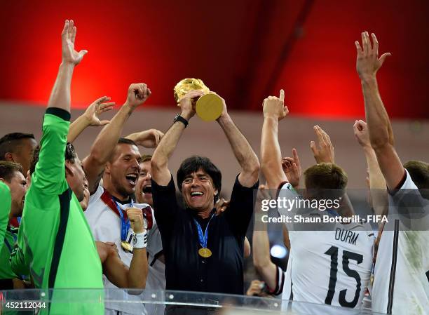 Head coach Joachim Loew of Germany lifts the World Cup to celebrate with his players during the award ceremony after the 2014 FIFA World Cup Brazil...