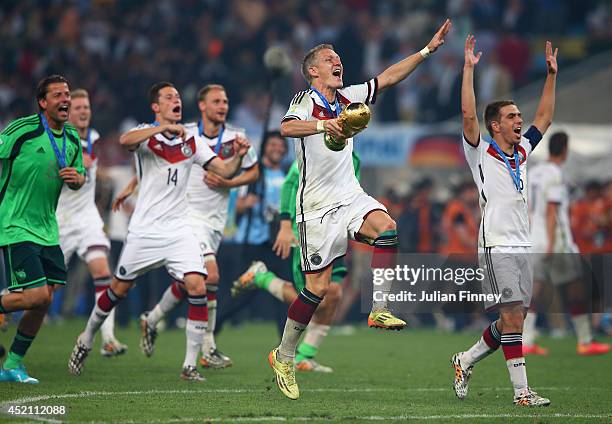 Bastian Schweinsteiger of Germany celebrates with the World Cup trophy after defeating Argentina 1-0 in extra time during the 2014 FIFA World Cup...