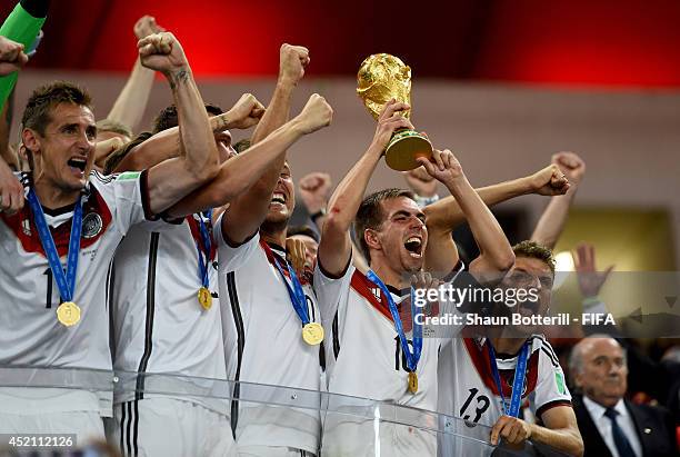 Philipp Lahm of Germany lifts the World Cup to celebrate with his teammates during the award ceremony after the 2014 FIFA World Cup Brazil Final...