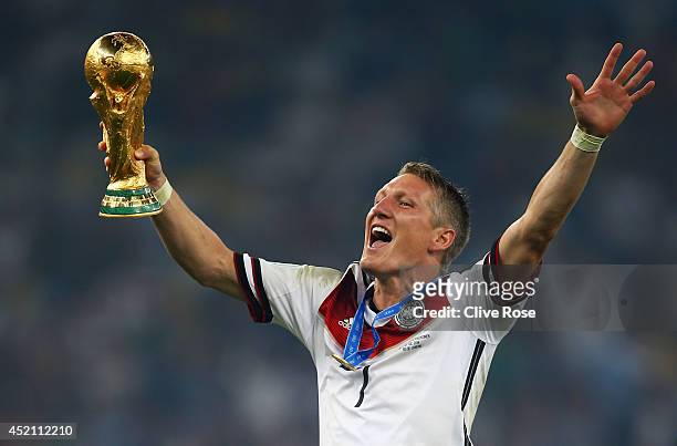Bastian Schweinsteiger of Germany celebrates with the World Cup trophy after defeating Argentina 1-0 in extra time during the 2014 FIFA World Cup...