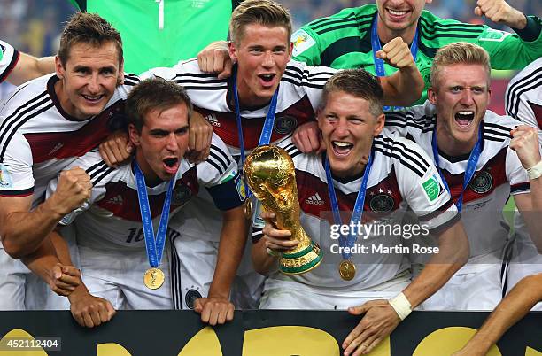 Miroslav Klose, Philipp Lahm, Erik Durm, Bastian Schweinsteiger and André Schürrle of Germany celebrate with the World Cup trophy after defeating...