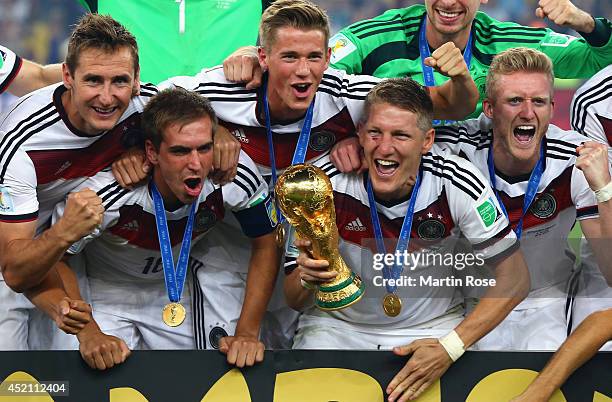 Miroslav Klose, Philipp Lahm, Erik Durm, Bastian Schweinsteiger and Toni Kroos of Germany celebrate with the World Cup trophy after defeating...