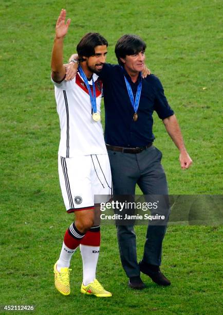 Sami Khedira of Germany celebrates with head coach Joachim Loew after defeating Argentina 1-0 in extra time during the 2014 FIFA World Cup Brazil...