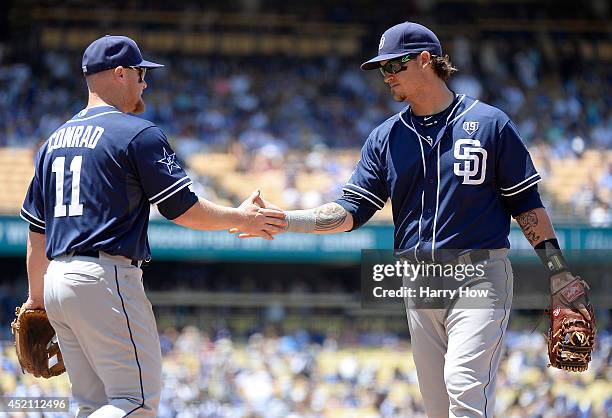 Brooks Conrad of the San Diego Padres celebrates his play with Yasmani Grandal for an out of Dee Gordon of the Los Angeles Dodgers during the third...