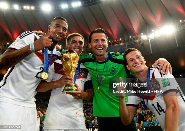 Philipp Lahm of Germany holds the World Cup to celebrate with his teammates Jerome Boateng , Roman Weidenfeller and Julian Draxler after the 2014...