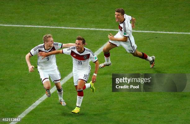 Mario Goetze of Germany celebrates scoring his team's first goal in extra time with Andre Schuerrle and Thomas Mueller during the 2014 FIFA World Cup...
