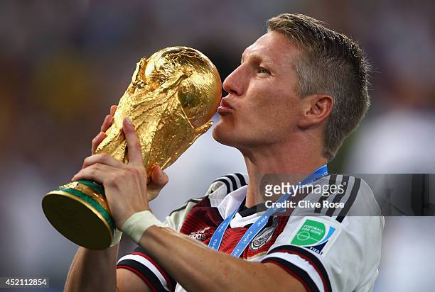 Bastian Schweinsteiger of Germany kisses the World Cup trophy after defeating Argentina 1-0 in extra time during the 2014 FIFA World Cup Brazil Final...