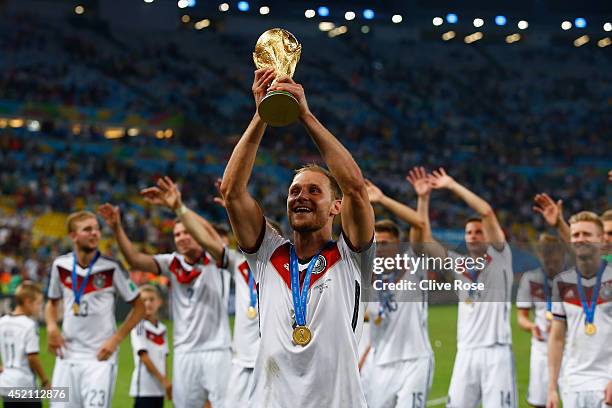 Benedikt Hoewedes celebrates with the World Cup trophy after defeating Argentina 1-0 in extra time during the 2014 FIFA World Cup Brazil Final match...