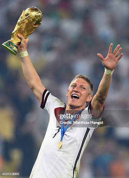 Bastian Schweinsteiger of Germany celebrates with the World Cup trophy after defeating Argentina 1-0 in extra time during the 2014 FIFA World Cup...