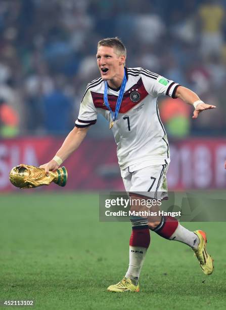 Bastian Schweinsteiger of Germany celebrates with the World Cup trophy after defeating Argentina 1-0 in extra time during the 2014 FIFA World Cup...