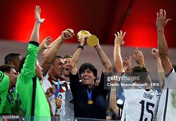 Head coach Joachim Loew of Germany lifts the World Cup to celebrate with his players during the award ceremony after the 2014 FIFA World Cup Brazil...