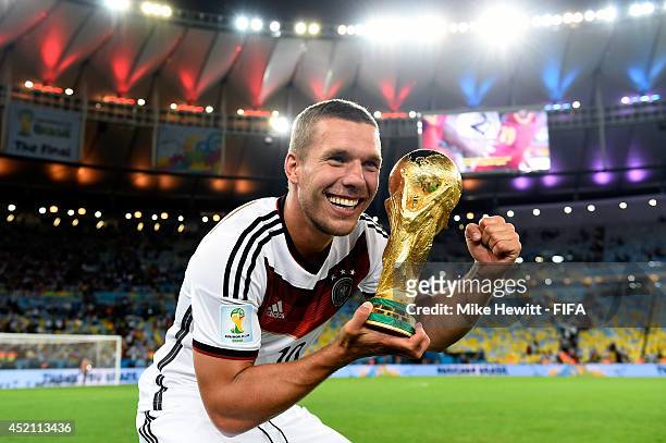 Lukas Podolski of Germany celebrates with the World Cup trophy after the 2014 FIFA World Cup Brazil Final match between Germany and Argentina at...