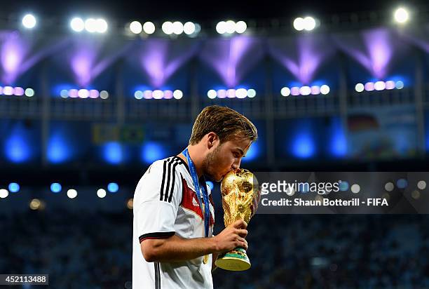 Mario Goetze of Germany kisses the World Cup trophy after the 2014 FIFA World Cup Brazil Final match between Germany and Argentina at Maracana on...