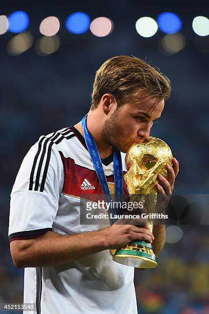 Mario Goetze of Germany kisses the World Cup trophy after defeating Argentina 1-0 in extra time during the 2014 FIFA World Cup Brazil Final match...