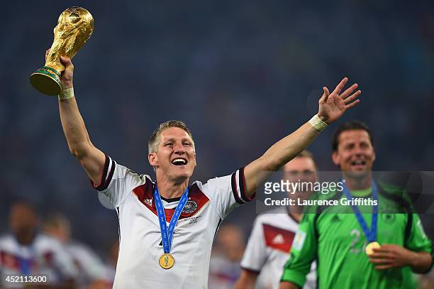 Bastian Schweinsteiger of Germany kisses the World Cup trophy after defeating Argentina 1-0 in extra time during the 2014 FIFA World Cup Brazil Final...