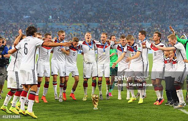Germany celebrate around the World Cup trophy after defeating Argentina 1-0 in extra time during the 2014 FIFA World Cup Brazil Final match between...