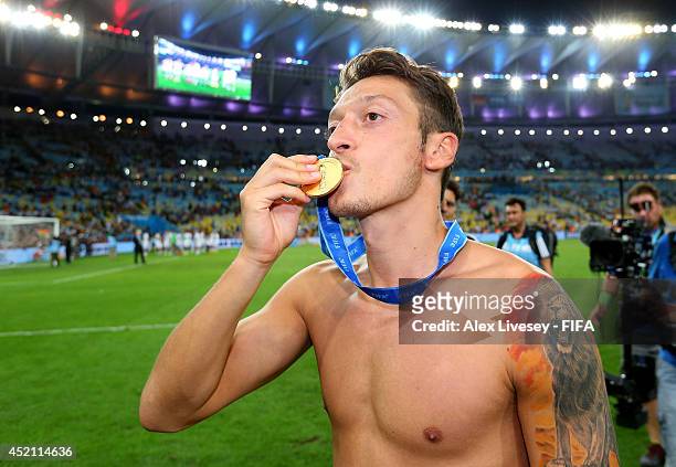Mesut Oezil of Germany kisses his winner's medal after the 2014 FIFA World Cup Brazil Final match between Germany and Argentina at Maracana on July...