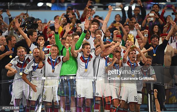 Philipp Lahm of Germany lifts the World Cup trophy and celebrates with teammates after defeating Argentina 1-0 in extra time during the 2014 FIFA...