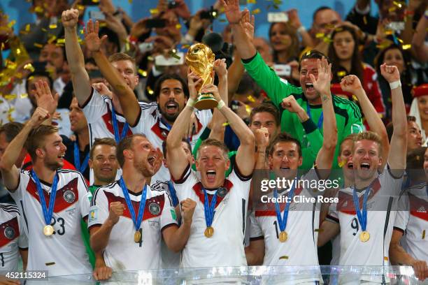 Bastian Schweinsteiger of Germany lifts the World Cup trophy with teammates after defeating Argentina 1-0 in extra time during the 2014 FIFA World...