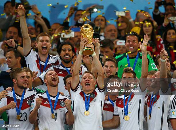 Bastian Schweinsteiger of Germany lifts the World Cup trophy with teammates after defeating Argentina 1-0 in extra time during the 2014 FIFA World...