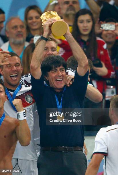 Head coach Joachim Loew of Germany raises the World Cup trophy after defeating Argentina 1-0 in extra time during the 2014 FIFA World Cup Brazil...