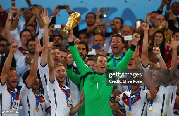 Manuel Neuer of Germany lifts the World Cup trophy with teammates after defeating Argentina 1-0 in extra time during the 2014 FIFA World Cup Brazil...